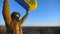 Ukrainian military medic holding waving flag of Ukraine. Female army soldier in uniform and helmet lifted up flag at the