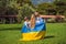 Ukrainian mother with two children with flag of Ukraine. Outside. Concept of problem of war in Europe, supporting of