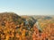 Ukrainian nature landscape. Monastery on hill. Narrow river flowing below the hills. Colorful autumn forest on hills