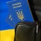 Ukrainian passport in a backpack against the background of the Ukrainian flag. Immigration of people in connection with the war