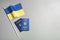 Ukrainian passports and national flag on grey background, top view. International relationships