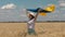 Ukrainian patriotic woman stands in wheat field and holds a blue-yellow flag of Ukraine