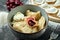 Ukrainian or Polish traditional dish - Pierogi or Varenyky dumplings stuffed with cherry and sour cream on a dark background.