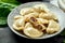 Ukrainian or Polish traditional dish - Pierogi or Varenyky dumplings stuffed with meat and sour cream. dark background. Close up