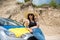 Ukrainian pretty girl with national flag posing in a sand quarry near the car