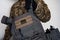 Ukrainian soldier in military pixel unform camouflage with grey bulletproof vest in one arm