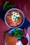 Ukrainian traditional borsch. Russian vegetarian red soup in blue bowl on red wooden background. Borscht, borshch with beet. To