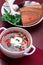 Ukrainian traditional borsch. Russian vegetarian red soup in white bowl on red wooden background. Borscht, borshch with beet.