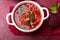 Ukrainian traditional borsch. Russian vegetarian red soup in white bowl on red wooden background. Top view. Borscht, borshch wit