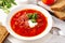 Ukrainian vegetable soup with bread, borscht with sour cream and parsley in a plate