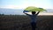 Ukrainian woman running with raised flag Ukraine above her head on wheat field at sunset. Lady jogging with national