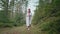 Ukrainian woman walking in fir forest, Carpathian mountains nature. Girl in traditional embroidery vyshyvanka dress