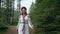 Ukrainian woman walking in fir forest, Carpathian mountains nature. Girl in traditional embroidery vyshyvanka dress, red