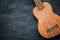 Ukulele on black cement background.