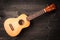 Ukulele on black wooden background. Acoustic music instruments. T