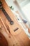 Ukulele: Close up of ukulele and flutes, ready to play, hanging on a wooden bookshelf