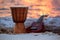 Ukulele and ethnic drum on a beach.