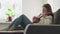 Ukulele in female hands. A woman learns to play the ukulele at home while sitting on the couch.