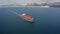 Ultra large container ship sailing at sea, aerial front view footage.