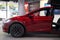 Ultra Red electric vehicle Tesla model X in Studio, SUV Powertrain in showroom, Green Driving, alternative energy development