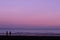 Ultra violet scenery. Couple and dog on beach