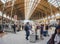 ultra wide-angle view of group of tourists with luggage on inside large Gare du