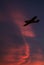 Ultralight aircraft flie over red flaming cloudscape