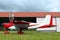 Ultralight airplane on green grass near hangar