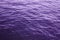 Ultraviolet sea water surface with purple waves background.