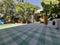 An ultrawide angle photo of a garden in Durban South Africa with some sunscreen and papert towel in the foreground and plants