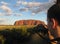 Uluru, Northern Territory, Australia 02/22/18. A photographer takin a shot of the ever changing colours of Uluru at sunset from a