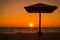 Umbrella on the beach against sunset