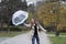 The umbrella flew to the side due to high winds.A young girl with long hair.