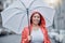 Umbrella, happy and portrait of a woman in the city walking in the rain while on a vacation. Travel, happiness and