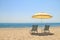 Umbrella and lounge chairs on idyllic beach