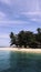 Umbrella tents and green sea water on the beach of Angso Duo Island, Padang Pariaman