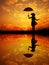 Umbrella woman and sunset silhouette,Water reflection