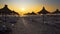 umbrellas are close on the beach against sunset