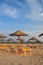 Umbrellas and deck lounges in the beach at sunset. Algarve, Portugal