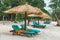 Umbrellas made of straw and chaise longue made of wood on a wonderful tropical beach, Beautiful beach, azure sea and white sand,