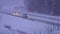 Umea, Sweden JANUARY 10, 2021: Two cars driving on winter highway, forest, field, no sun, heavy snowfall, typical winter weather