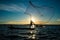 Un-identified silhouette fisher man on boat fishing by throwing