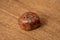 Unakit rare gemstone shiny polished different tones of brown red and orange on wooden underground