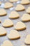 Unbaked heart shaped shortbread cookies on baking tray, selective focus
