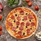 Unbaked pizza with cheese, salami and olives, top view