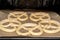 Unbaked pretzels on baking paper in the oven