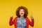 Unbelievable advertise here! Portrait of amazed curly-haired woman pointing up and looking with open mouth