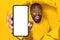 Unbelievable offer. Shocked black man holding smartphone with empty screen, showing it through yellow paper sheet