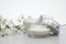 Unbranded Beauty cream and white flowers on light gray background