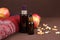 Unbranded dark brown spray bottle, serum with hyaluronic acid in brown glass bottle and red knitted sweater, apples and dry